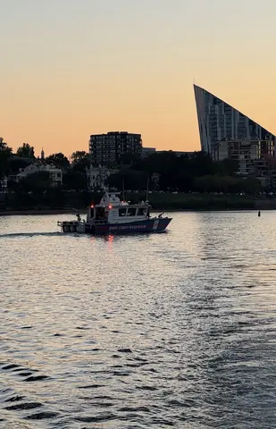 Rescue vessel 220 patrolling downriver at dusk, with the shore of Covington, KY in the background..